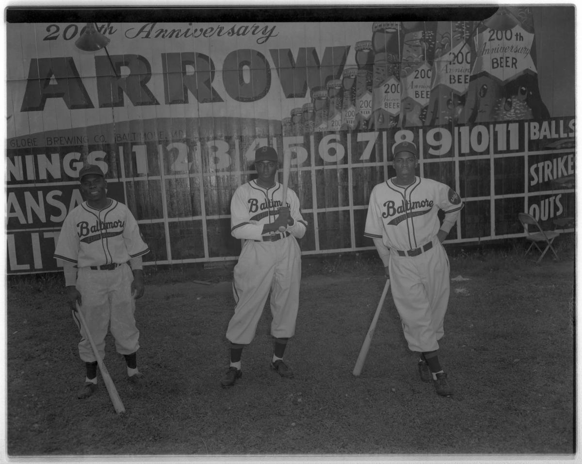 Black and white photo of three players holding baseball bats