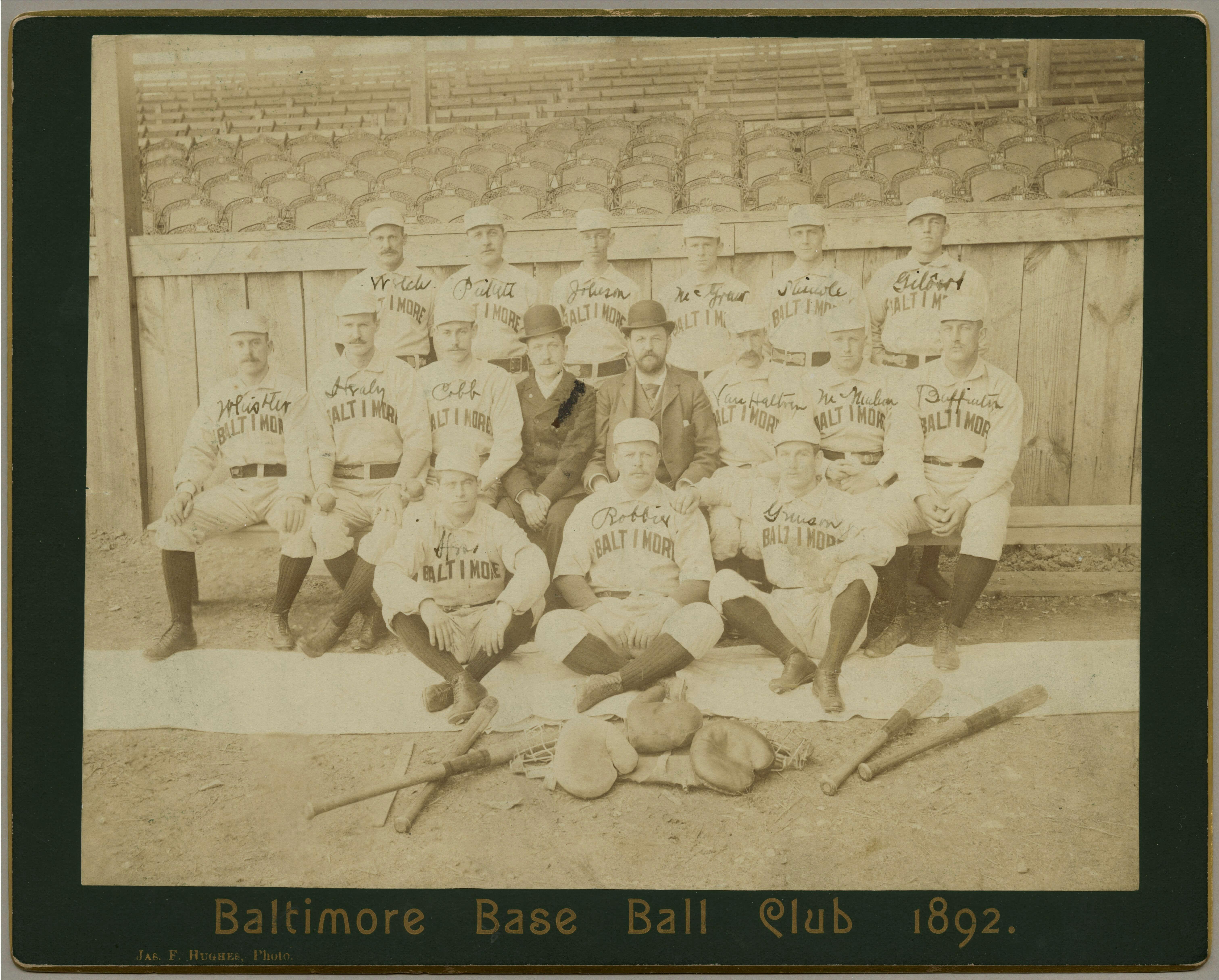 1892 Baltimore Base Ball Club team photo with players posed in front of empty wooden grandstand seats.