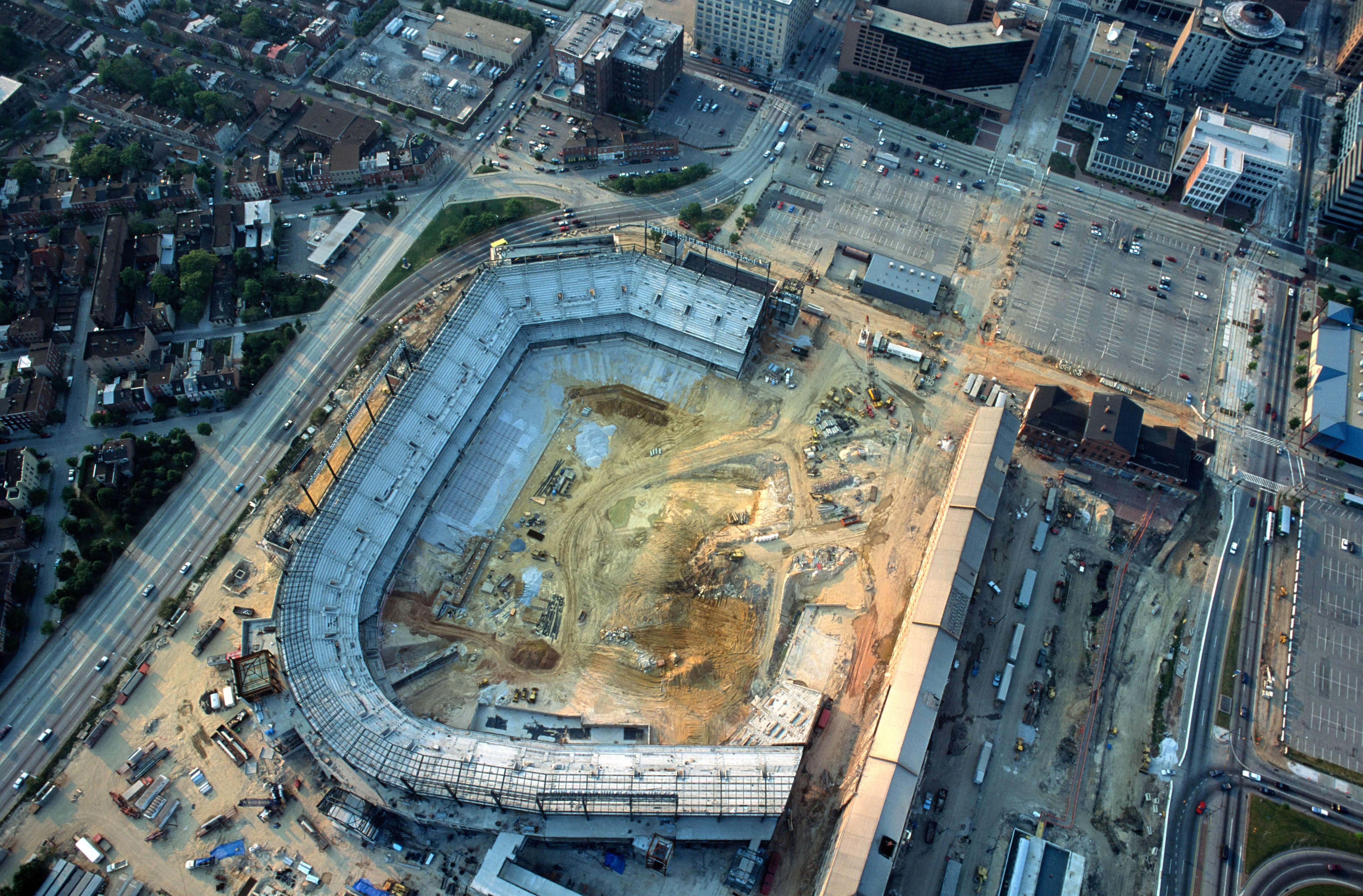 Aerial view looking straight down at Camden Yards during construction, showing partially completed seating bowl and surrounding streets.