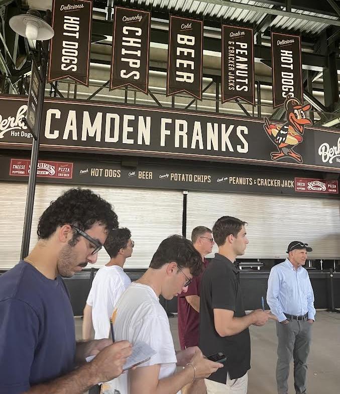 Students taking notes in front of the Camden Franks food counter