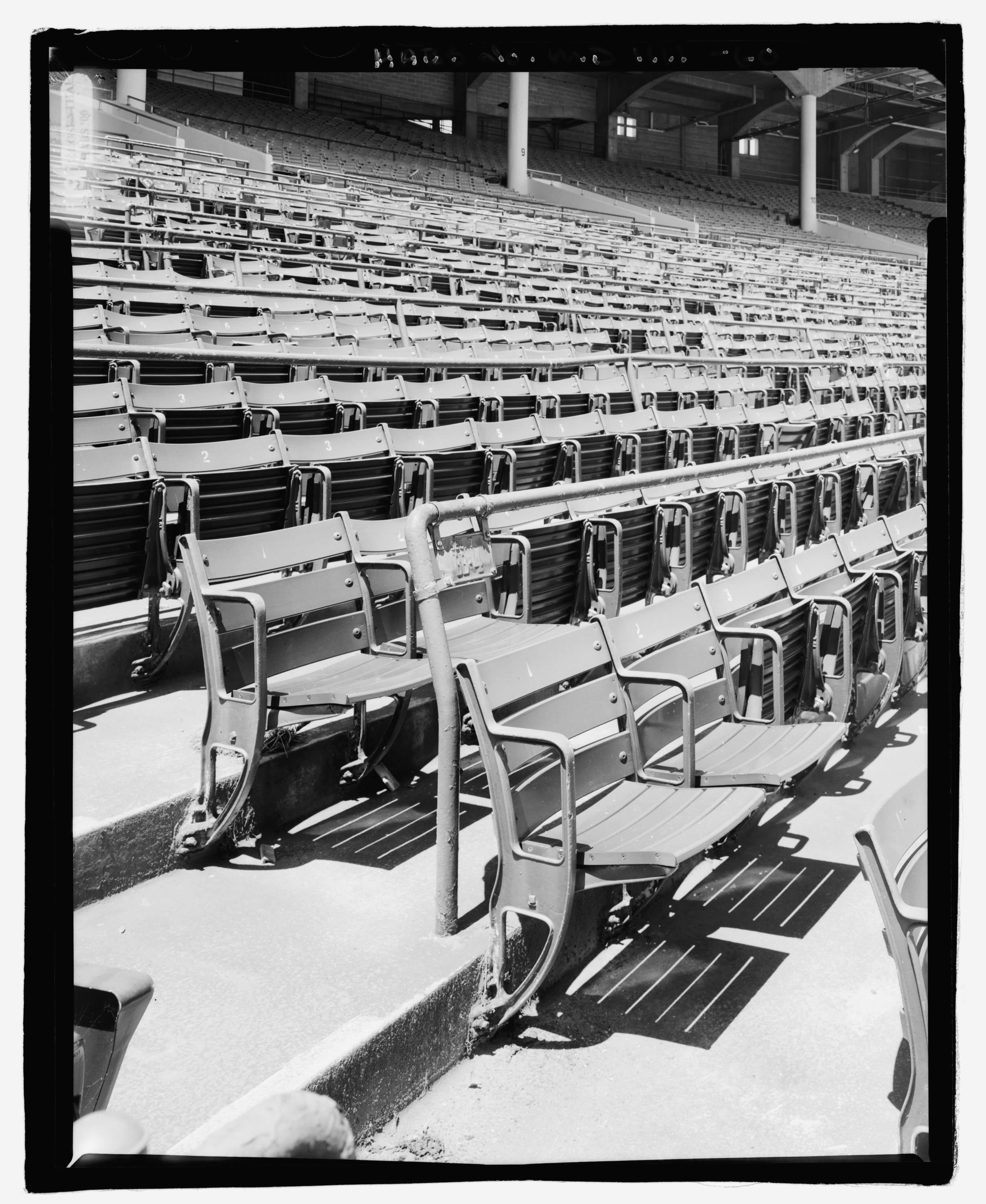 Black and white photo of rows of empty stadium seats