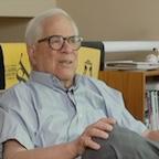 Man talking with glasses and blue button down shirt