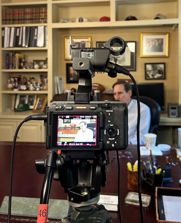 Camera in the foreground recording Alan Rifken in the background